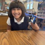 Shared Science Long Beach elementary school student holding LEGO robot